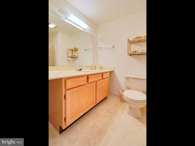 bathroom with baseboards, vanity, and toilet