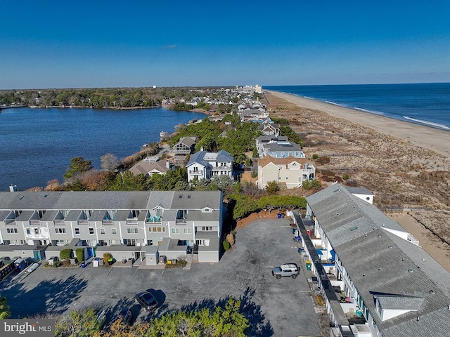 drone / aerial view featuring a residential view, a water view, and a beach view