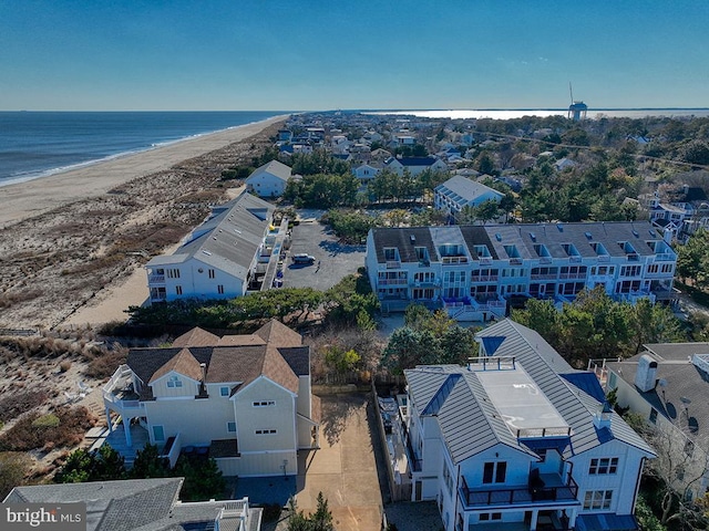 aerial view with a view of the beach, a water view, and a residential view