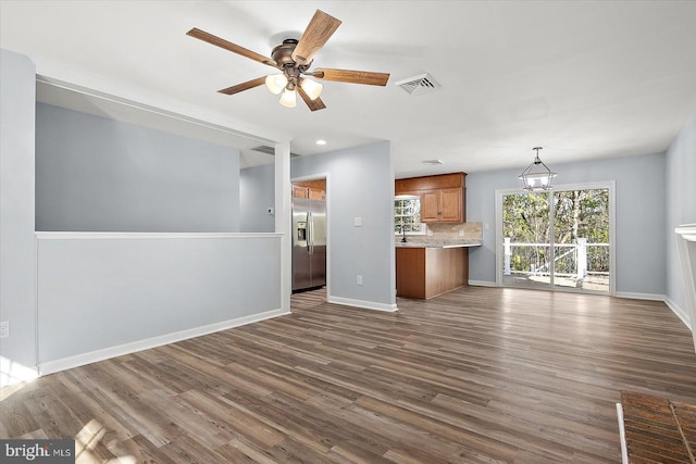 unfurnished living room with ceiling fan and dark hardwood / wood-style flooring