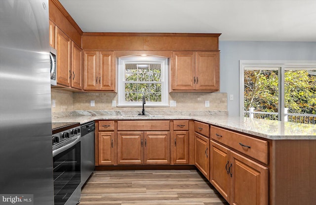 kitchen featuring sink, kitchen peninsula, stainless steel appliances, and tasteful backsplash