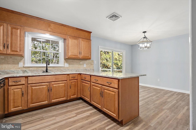 kitchen with sink, hanging light fixtures, tasteful backsplash, a notable chandelier, and kitchen peninsula