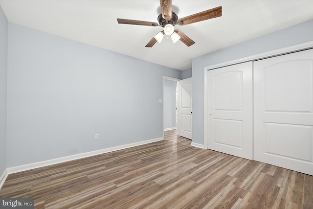 unfurnished bedroom with hardwood / wood-style floors, a closet, and ceiling fan