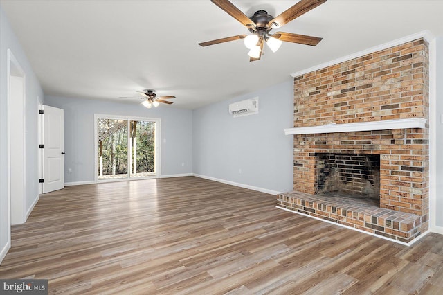 unfurnished living room with a brick fireplace, ceiling fan, hardwood / wood-style flooring, and a wall mounted AC