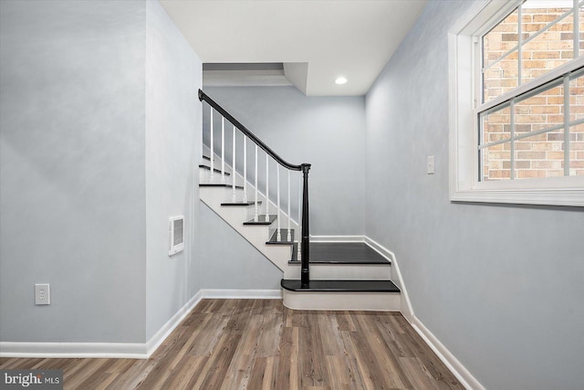 stairs with a wealth of natural light and wood-type flooring