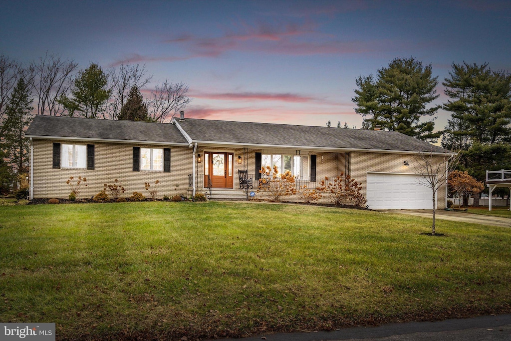 single story home with a lawn and a garage