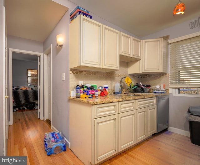 kitchen with decorative backsplash, cream cabinets, light hardwood / wood-style floors, and stainless steel dishwasher