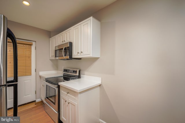 kitchen featuring white cabinetry, light wood-type flooring, and appliances with stainless steel finishes