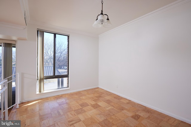 spare room featuring light parquet floors, ornamental molding, and an inviting chandelier