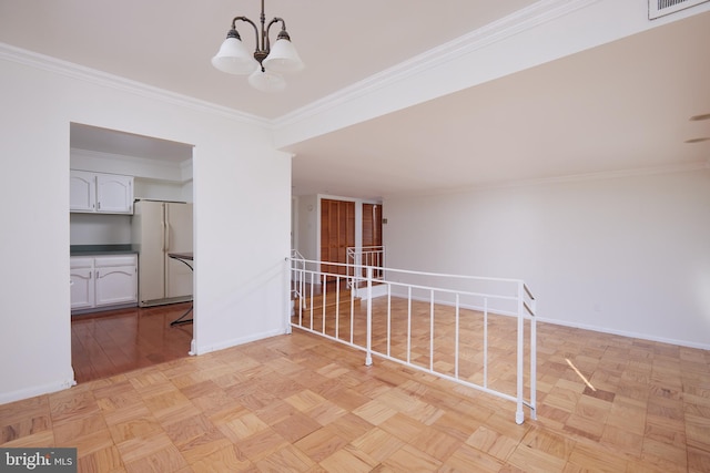 unfurnished room featuring an inviting chandelier, light parquet flooring, and crown molding