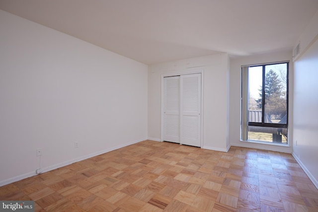 unfurnished bedroom with a closet and light parquet floors