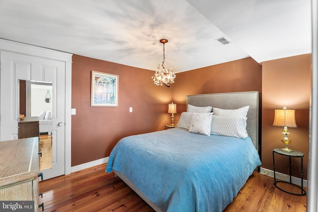 bedroom featuring a chandelier and wood-type flooring