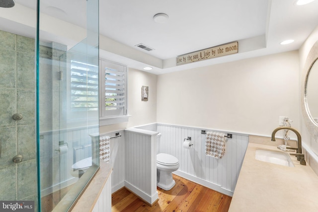 bathroom featuring toilet, an enclosed shower, vanity, and hardwood / wood-style floors