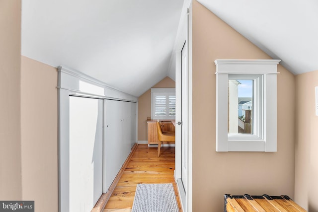 bonus room with light wood-type flooring and lofted ceiling