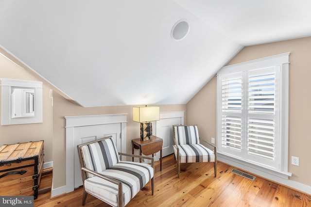 sitting room featuring vaulted ceiling and light hardwood / wood-style flooring