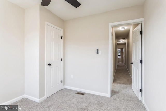 unfurnished bedroom featuring light carpet and ceiling fan