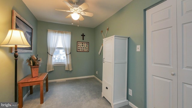 interior space featuring light carpet and ceiling fan