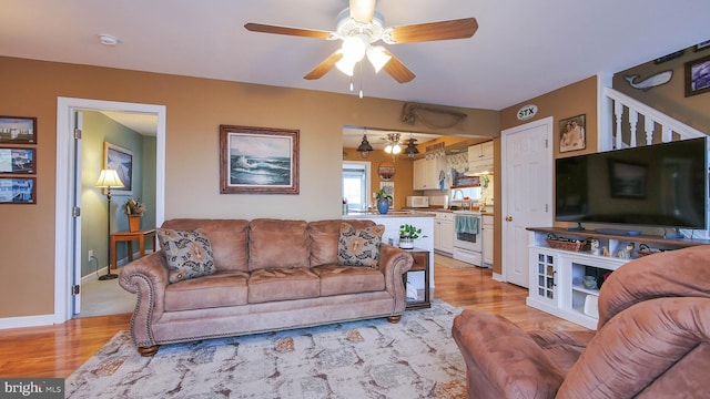 living room featuring light hardwood / wood-style floors and ceiling fan