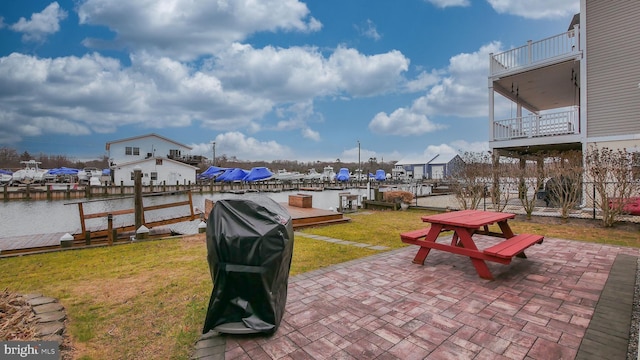 view of patio featuring area for grilling, a water view, and a balcony