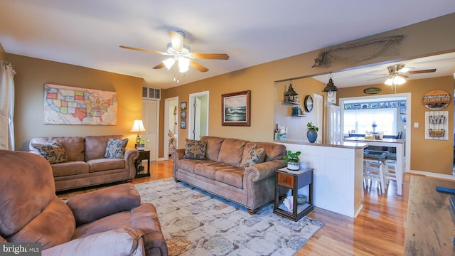 living room featuring light hardwood / wood-style floors and ceiling fan