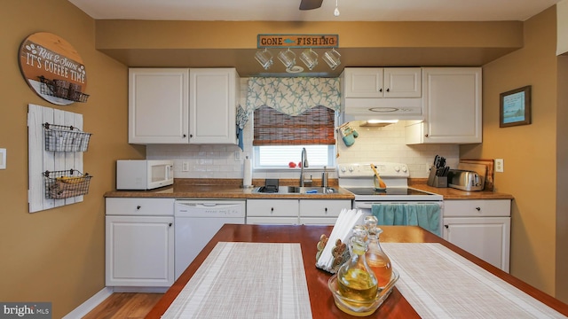 kitchen featuring white cabinets, white appliances, backsplash, and sink