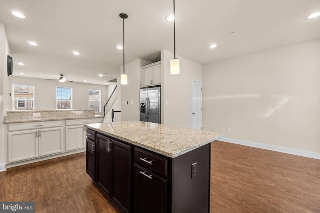 kitchen with dark wood-type flooring, white cabinets, stainless steel refrigerator with ice dispenser, ceiling fan, and decorative light fixtures