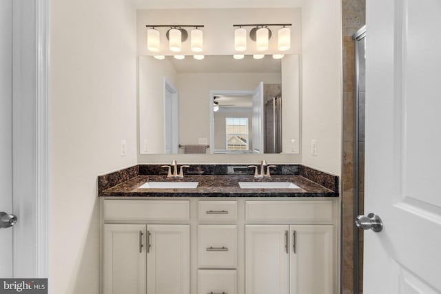 bathroom featuring walk in shower, vanity, and ceiling fan