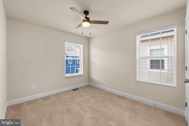 spare room featuring ceiling fan and light colored carpet