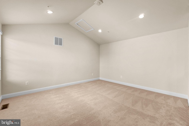 carpeted empty room with vaulted ceiling