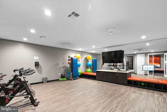 workout area with light hardwood / wood-style flooring