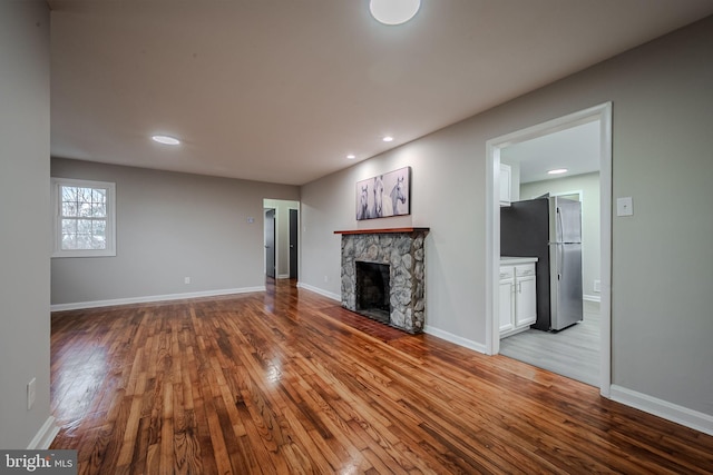 unfurnished living room featuring a fireplace and light hardwood / wood-style flooring