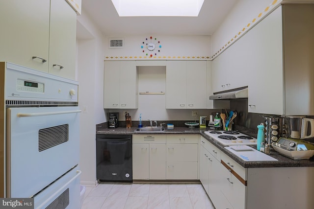 kitchen featuring white cabinets, white appliances, sink, and a skylight