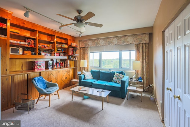 living area featuring light carpet, ceiling fan, and track lighting