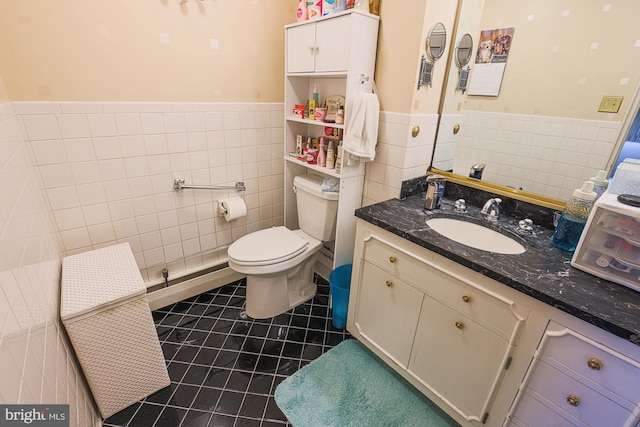 bathroom featuring tile patterned floors, vanity, toilet, and tile walls