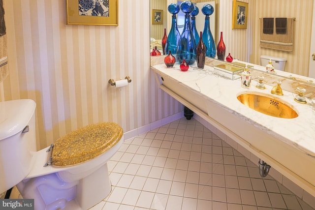 bathroom featuring toilet, sink, and tile patterned flooring