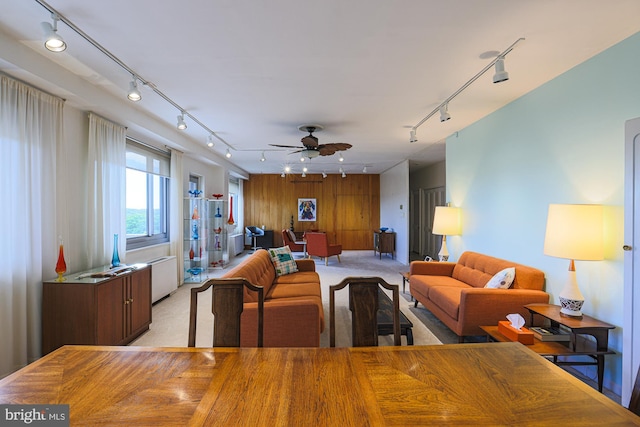 carpeted dining room with track lighting and ceiling fan