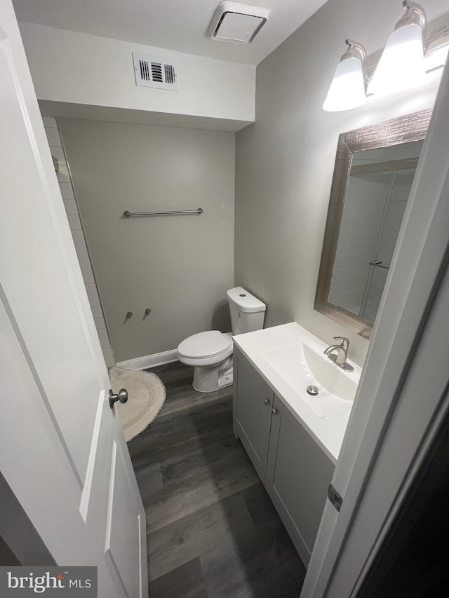 bathroom with hardwood / wood-style floors, vanity, and toilet