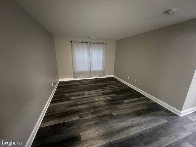 empty room with dark hardwood / wood-style flooring