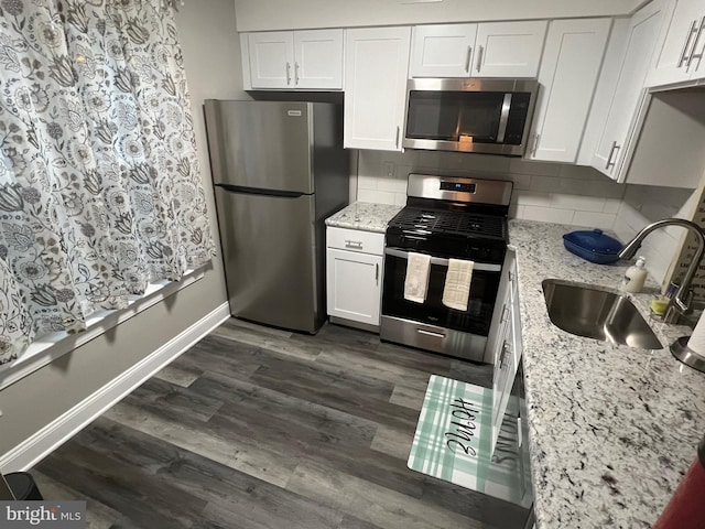 kitchen with sink, dark hardwood / wood-style floors, backsplash, white cabinets, and appliances with stainless steel finishes