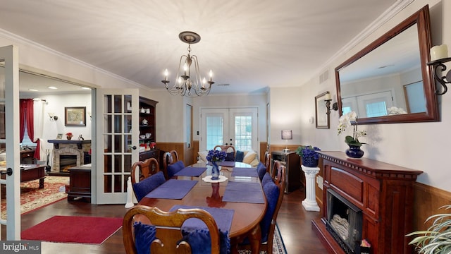 dining space with a fireplace, french doors, and ornamental molding