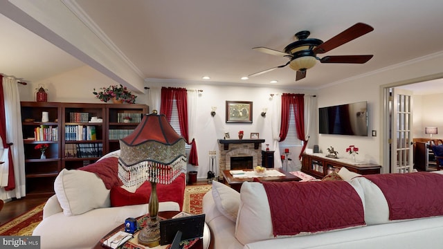 living room with vaulted ceiling, hardwood / wood-style flooring, ceiling fan, ornamental molding, and a fireplace