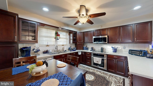 kitchen featuring decorative backsplash, appliances with stainless steel finishes, ceiling fan, and sink