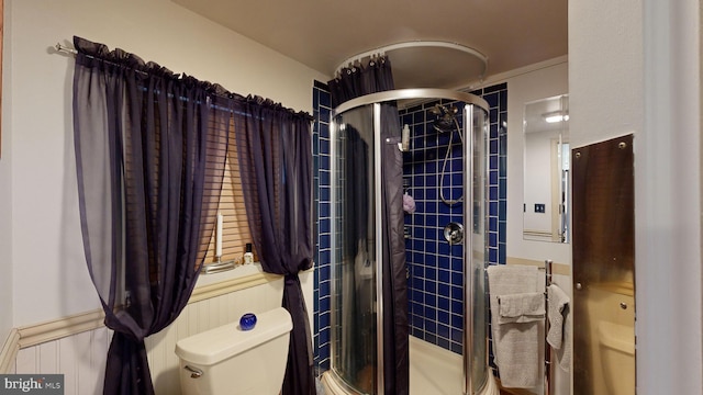 bathroom with toilet and a shower with shower door