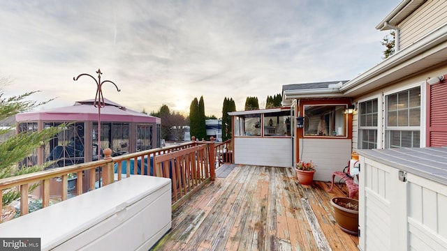 deck at dusk featuring a gazebo