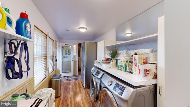 clothes washing area with separate washer and dryer and hardwood / wood-style flooring