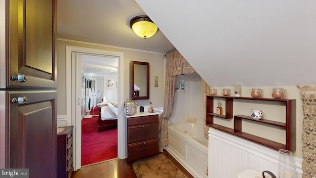 bathroom with hardwood / wood-style floors, vanity, a bathtub, and crown molding