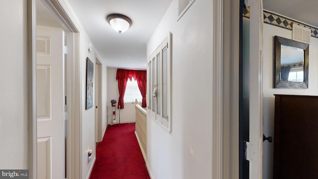 hall featuring dark colored carpet