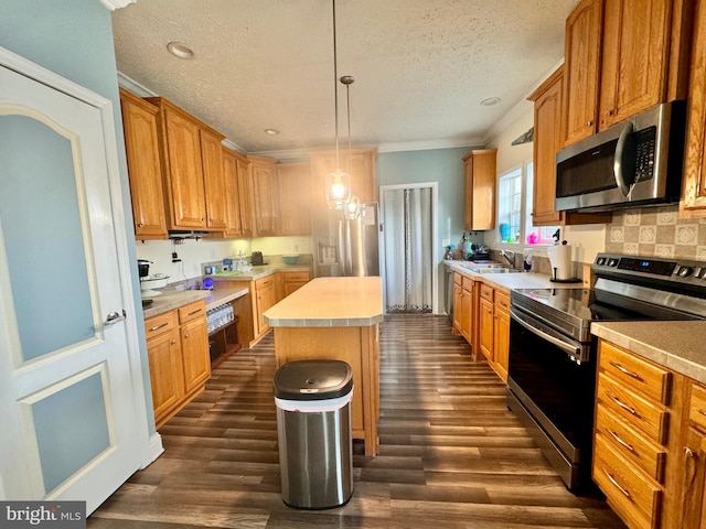 kitchen featuring sink, a center island, dark hardwood / wood-style flooring, pendant lighting, and appliances with stainless steel finishes