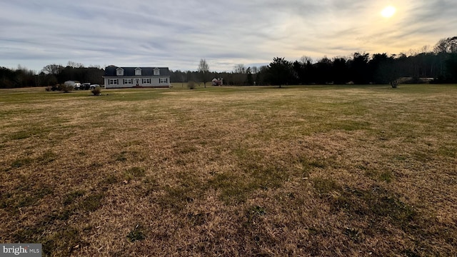 yard at dusk featuring a rural view