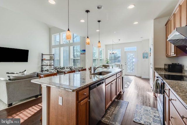 kitchen featuring sink, an island with sink, dark hardwood / wood-style flooring, stainless steel appliances, and a chandelier